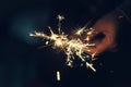 Female hands holding sparkler with night background